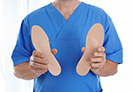 Podiatrist holding orthotics